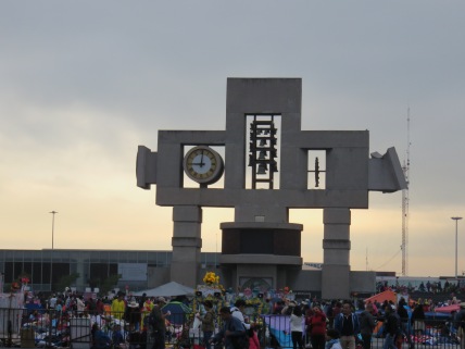 Large clock and sculpture on the border of the plaza where the pilgrims camp out.
